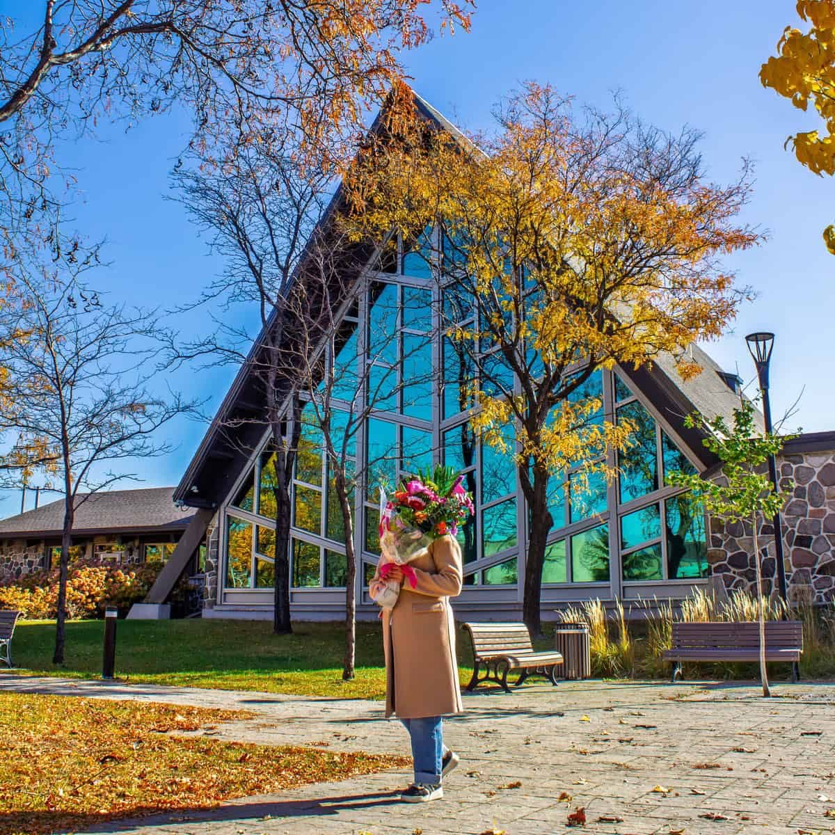 Person holding a colourful bouquet in front of Anjou City Hall in Montreal