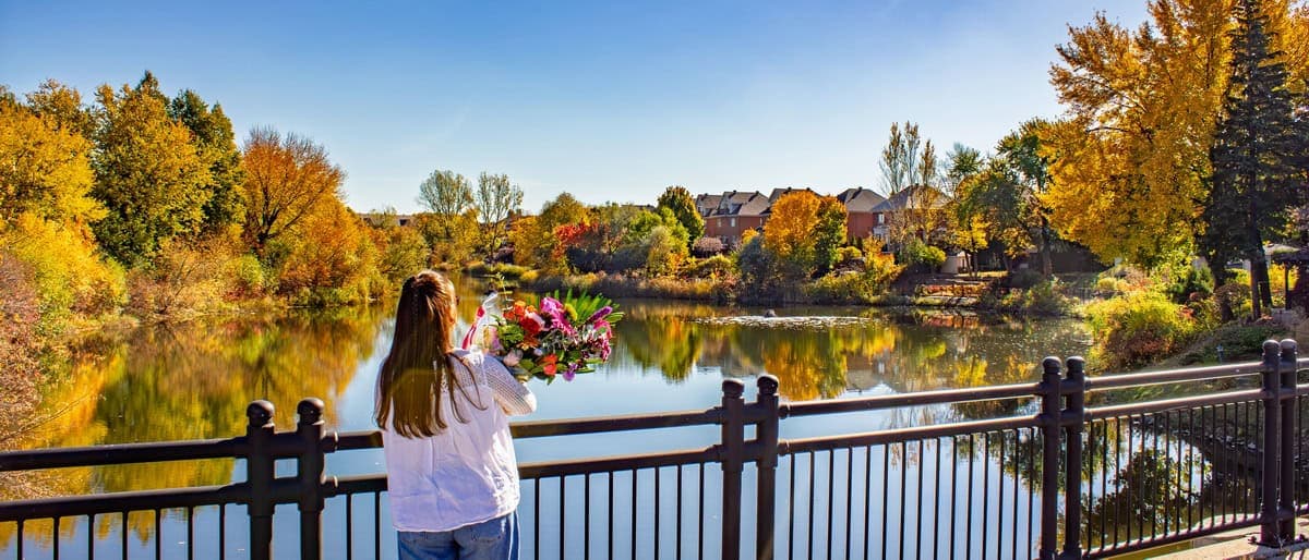Person holding a colourful bouquet by the lake at Parc Anjou-sur-le-Lac in Montreal