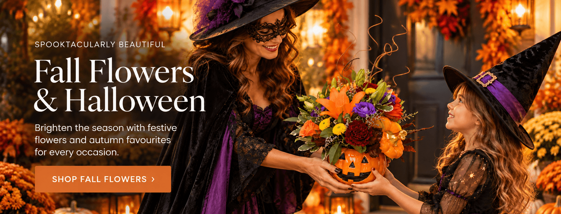 Halloween floral arrangement in a pumpkin vase with orange lilies, roses and colourful fall flowers, presented by two witches.
