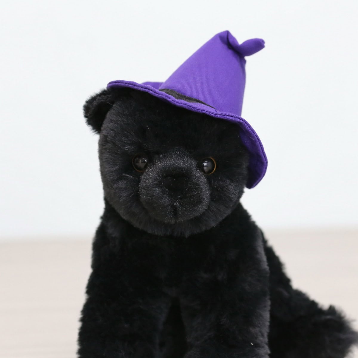 Add a touch of Halloween magic with our black cat plush wearing a purple witch hat. Perfect for floral arrangements, gifts, or seasonal decorations. Available at Le Bouquet.