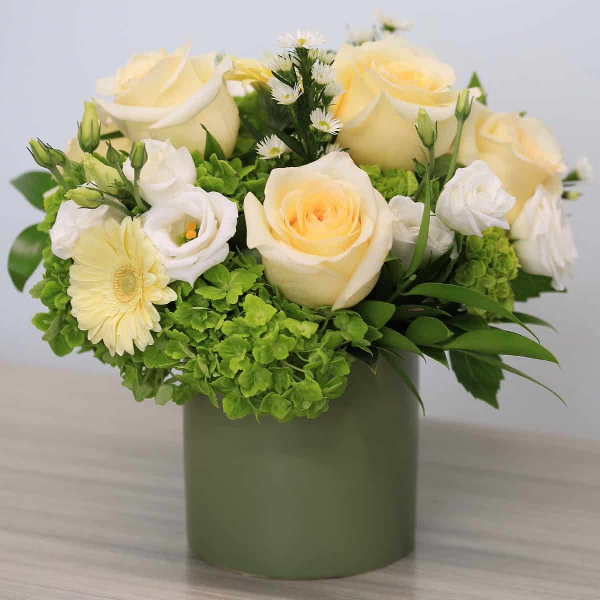 Garden Harmony spring flower arrangement featuring ivory roses and green hydrangea in a compact 10-inch vase design.