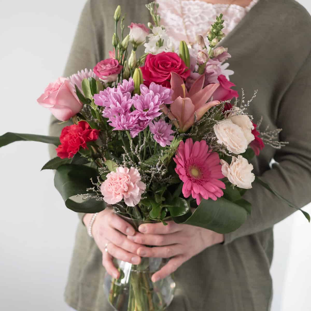Hand-tied Mother’s Day bouquet with roses, lilies and hydrangea held by woman