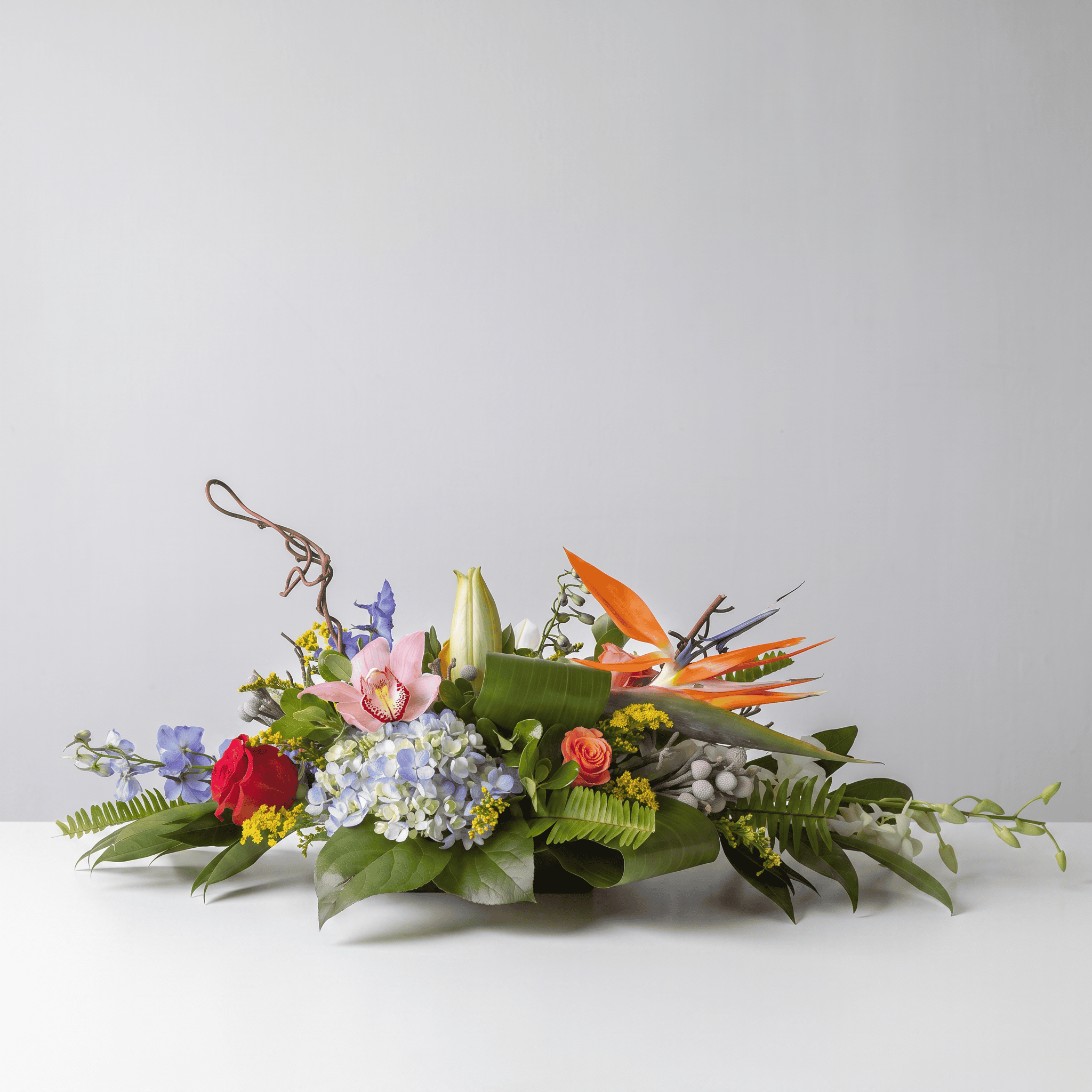 Standard Exotic Oval Centerpiece with birds of paradise, orchids, hydrangea, lilies and tropical flowers.