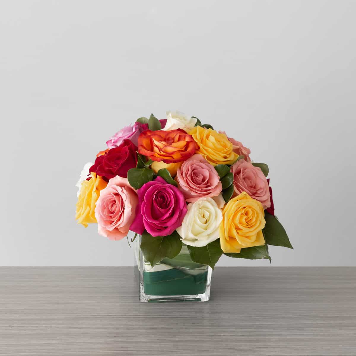 Premium Lush Life Roses arrangement with 24 assorted premium roses in a clear glass cube vase.