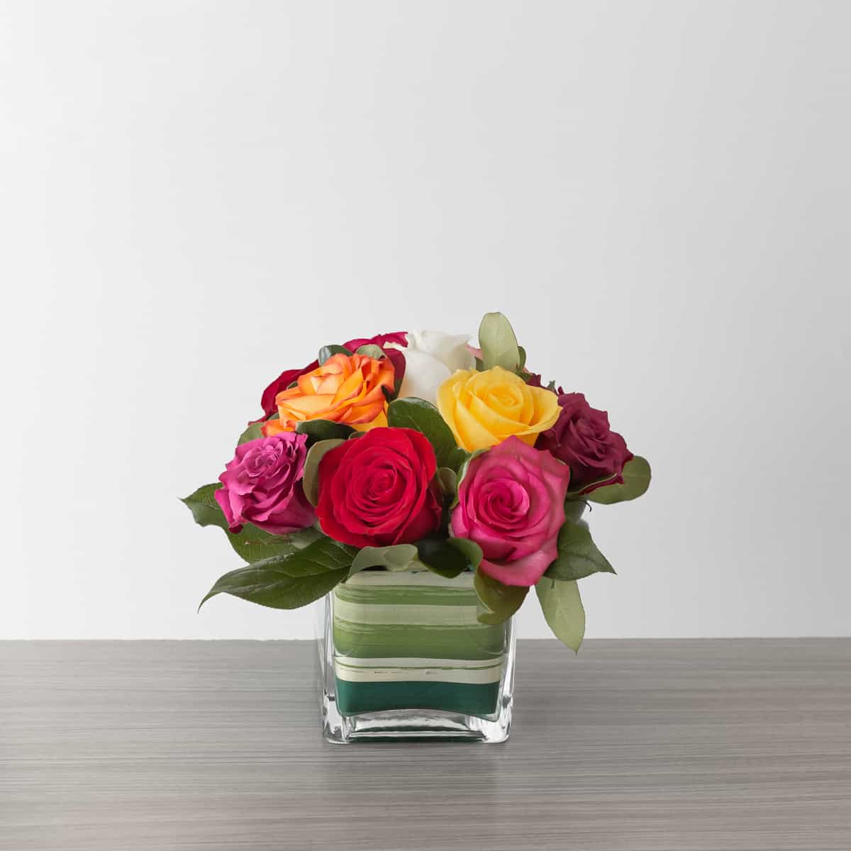 Lush Life Roses standard arrangement with 12 assorted premium roses in a clear glass cube vase.