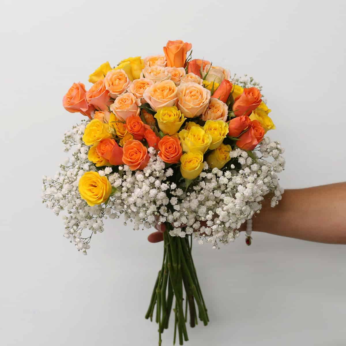 Standard Peach Romance hand-tied bouquet with peach, orange and yellow spray roses and baby's breath.