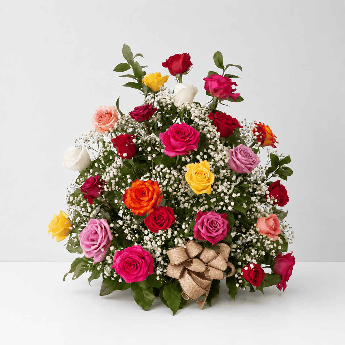Rose Rush one-sided assorted rose arrangement featuring red, pink, yellow and white roses with baby's breath, greenery and a burlap bow.