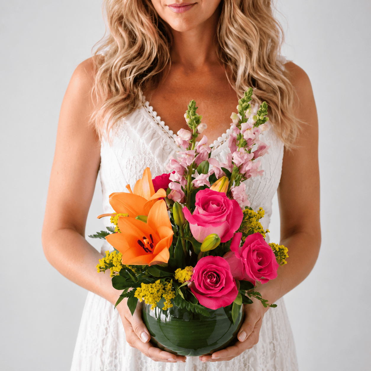 Person holding the Warmer Days floral arrangement with pink roses, orange lilies, pink snapdragons and golden solidago.
