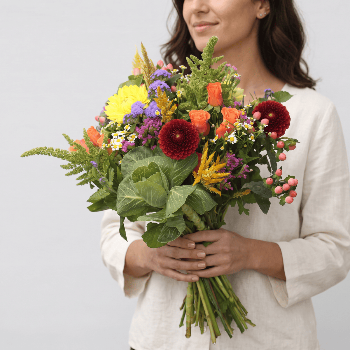 Woman holding the Countryside Charm hand-tied bouquet with dahlias, roses and seasonal flowers