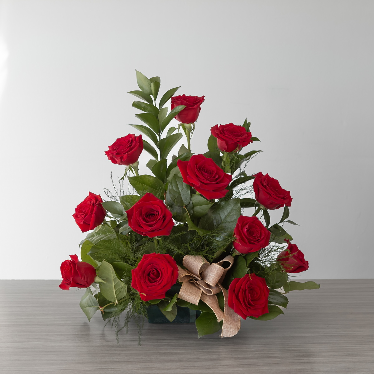 Side view of the Standard Red Rose Rush arrangement with 12 premium red roses and greenery
