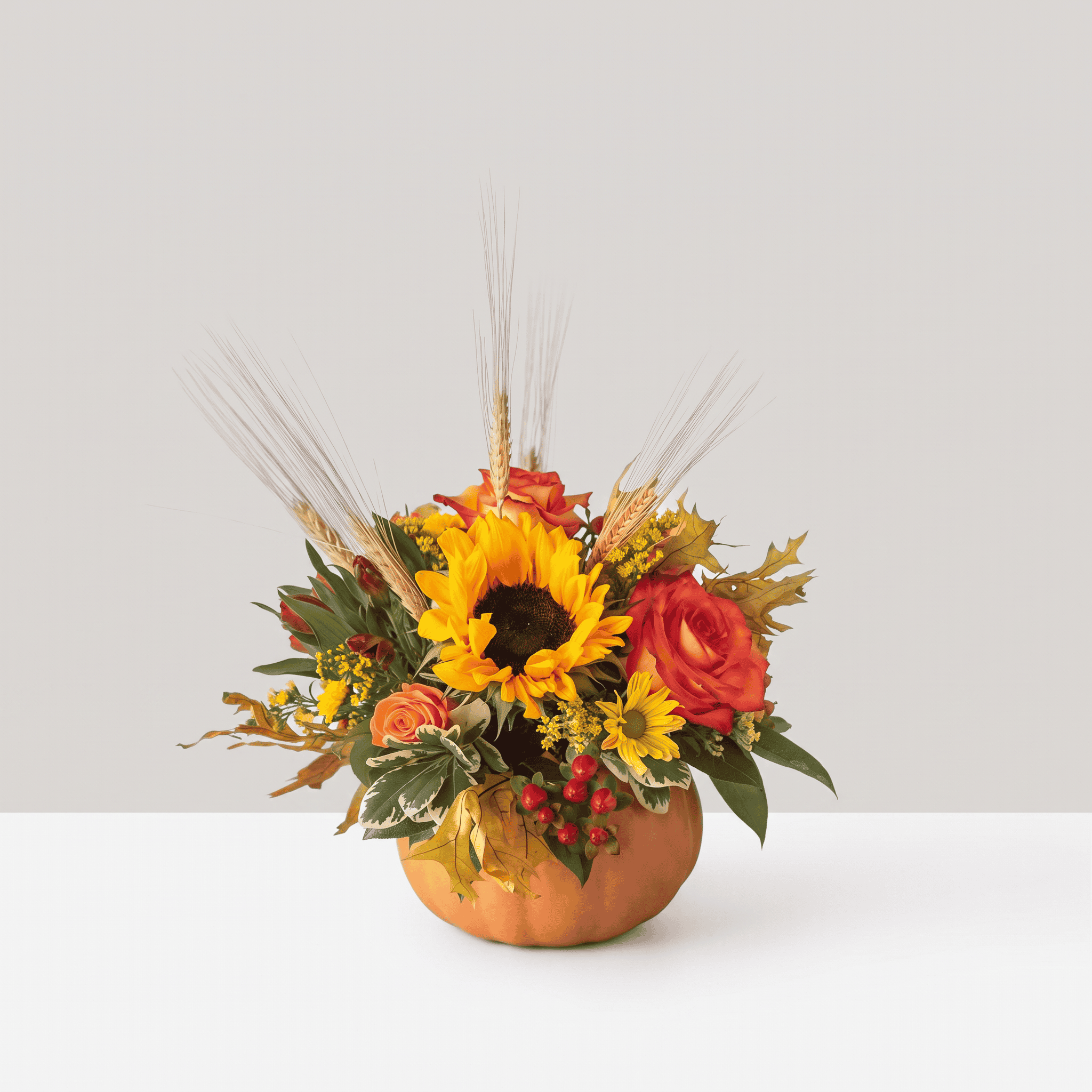 Harvest Pumpkin fall flower arrangement with sunflower, orange roses, wheat and autumn foliage in a ceramic pumpkin