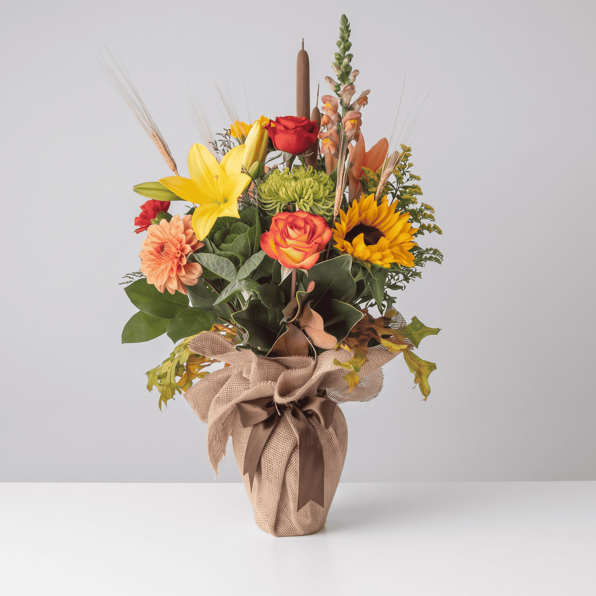 Seasonal Fall Bouquet with sunflower, roses, lilies and colourful autumn flowers arranged in a vase